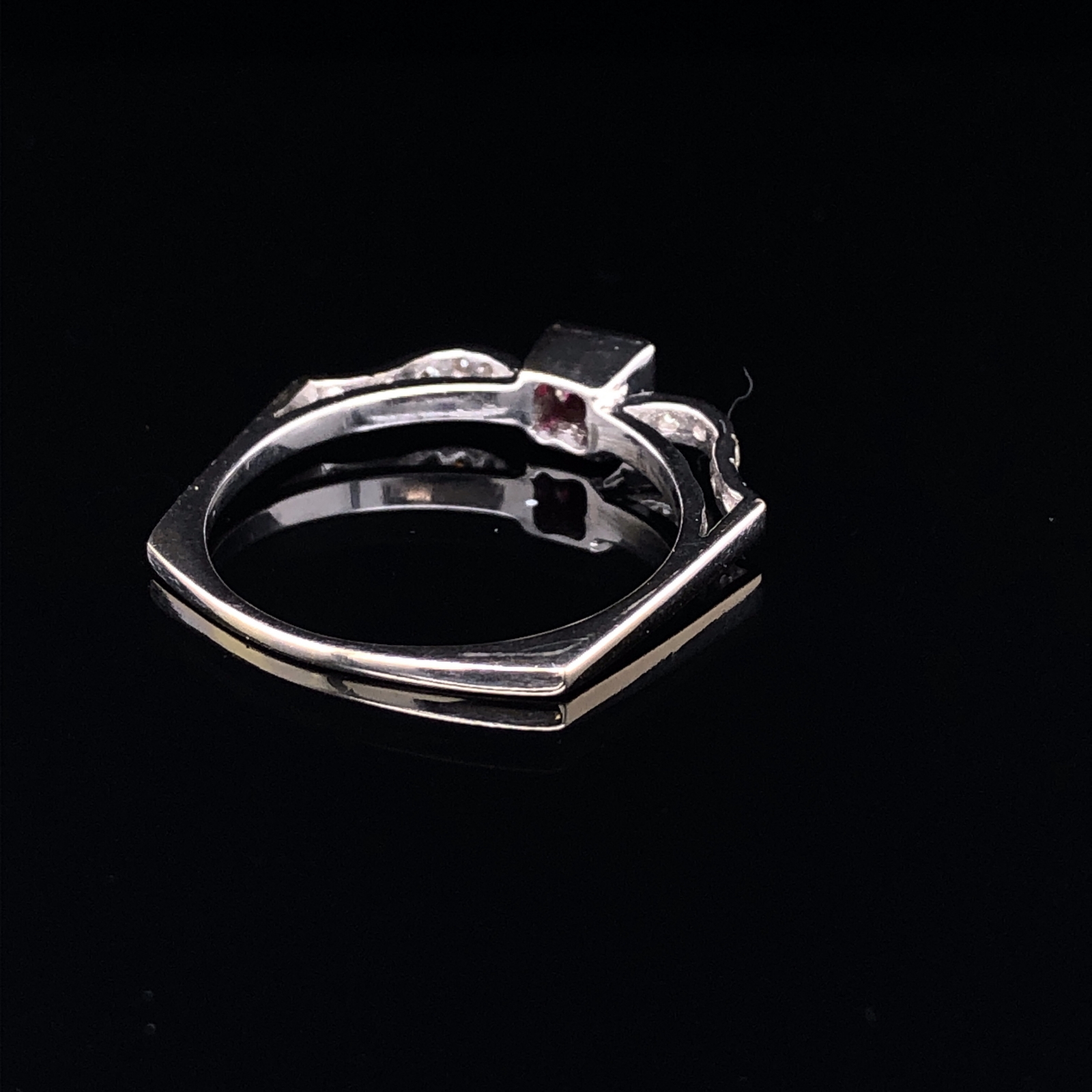 AN 18ct WHITE GOLD UNHALLMARKED RUBY AND DIAMOND RING. THE CENTRAL RUBY PRINCESS CUT IN A RUBOVER - Image 4 of 5