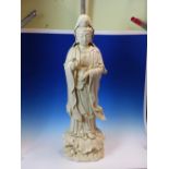 A BLANC DE CHINE FIGURE OF GUANYIN STANDING ON A LOTUS LEAF HER RIGHT HAND IN WELCOME GESTURE, A