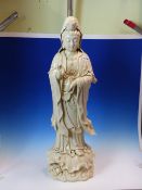 A BLANC DE CHINE FIGURE OF GUANYIN STANDING ON A LOTUS LEAF HER RIGHT HAND IN WELCOME GESTURE, A