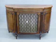 AN INLAID MAHOGANY REGENCY STYLE BREAK BOWFRONT CABINET WITH BRASS LATTICE DOOR. 123 x 40 x 84cms.