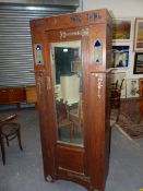 AN ARTS AND CRAFTS LIBERTYS TASTE OAK MIRRORED WARDROBE AND DRESSING TABLE, THE FORMER WITH COPPER