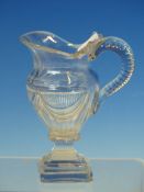 AN EARLY 19th C. CUT GLASS BALUSTER JUG, THE SIDES OF THE HANDLE CUT WITH OVALS, THE SOCLE AND