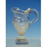 AN EARLY 19th C. CUT GLASS BALUSTER JUG, THE SIDES OF THE HANDLE CUT WITH OVALS, THE SOCLE AND