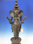 TWO SRI LANKHAN BRONZE FIGURES OF GANESH STANDING HOLDING ATTRIBUTES IN HIS TWO LEFT HANDS AND