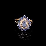 AN 18ct GOLD HALLMARKED SAPPHIRE AND DIAMOND TEARDROP CLUSTER RING. THE CENTRAL SAPPHIRE BEING A