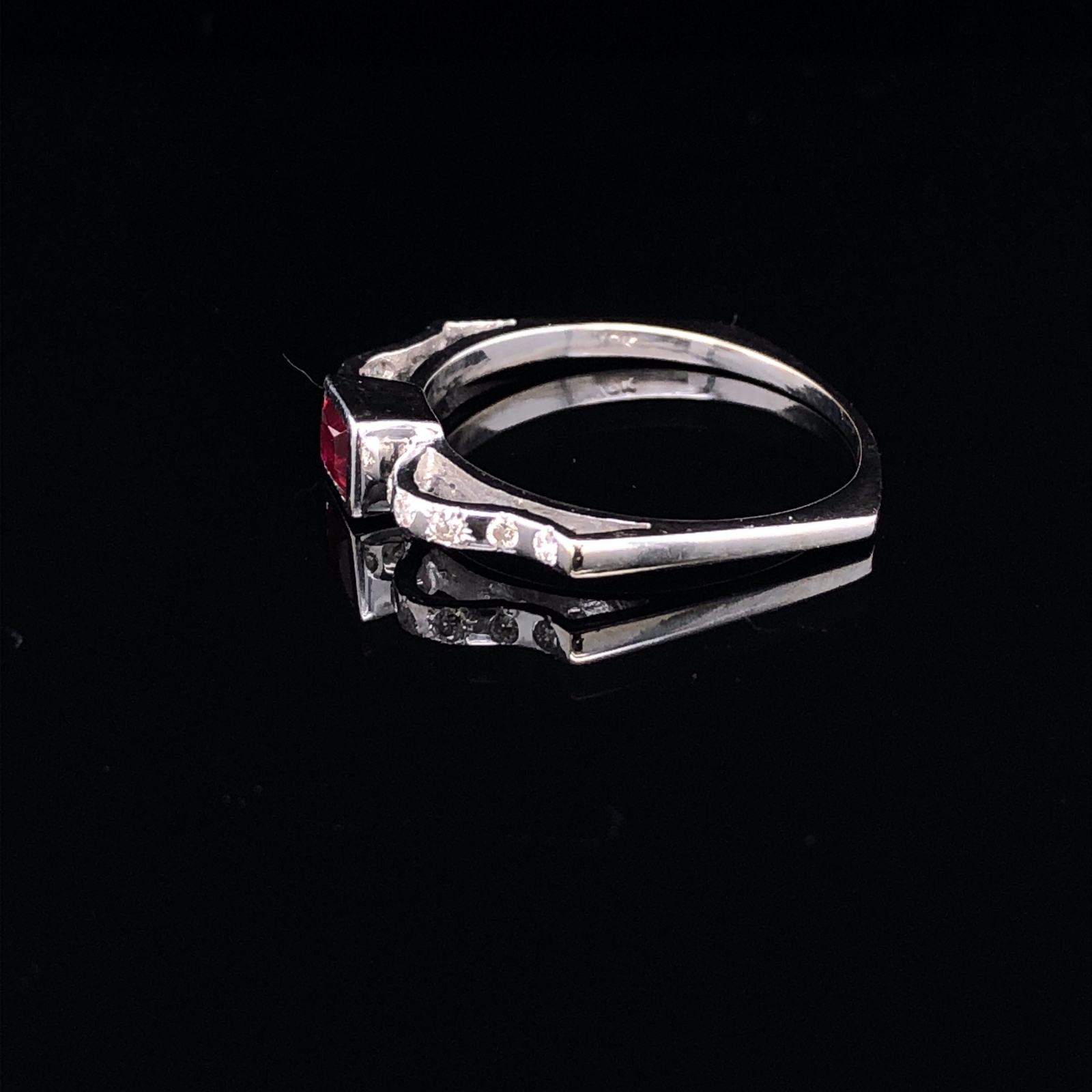 AN 18ct WHITE GOLD UNHALLMARKED RUBY AND DIAMOND RING. THE CENTRAL RUBY PRINCESS CUT IN A RUBOVER - Image 5 of 5