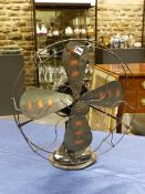 A GEC ELECTRIC FAN, EACH OF THE FOUR BLACK BLADES WITH THREE COPPER.THE MOTOR SUPPORTED ON TRUMPET