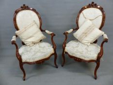 A PAIR OF VICTORIAN FRENCH STYLE WALNUT SHOW FRAME OPEN ARMCHAIRS ON SLENDER CABRIOLE LEGS AND CREAM