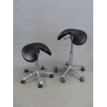 A PAIR OF SALLI BLACK LEATHER SADDLE STOOLS ADJUSTABLE ON TUBULAR CHROME COLUMNS EACH RESTING ON