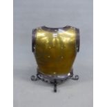 A STEEL EDGED BRASS CUIRASS BACK PLATE MOUNTED AS A FIRE GUARD. W 37 x H 58cms.