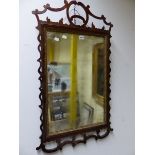 A GEORGE III RECTANGULAR MIRROR WITHIN GILT SLIP AND PIERCED CUT WORK FRAME CRESTED BY A ROUNDEL