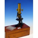 A MAHOGANY CASED BRASS MONOCULAR MICROSCOPE, A FOLD DOWN LENS ABOVE THE BLACKENED STAGE, THE BOX.