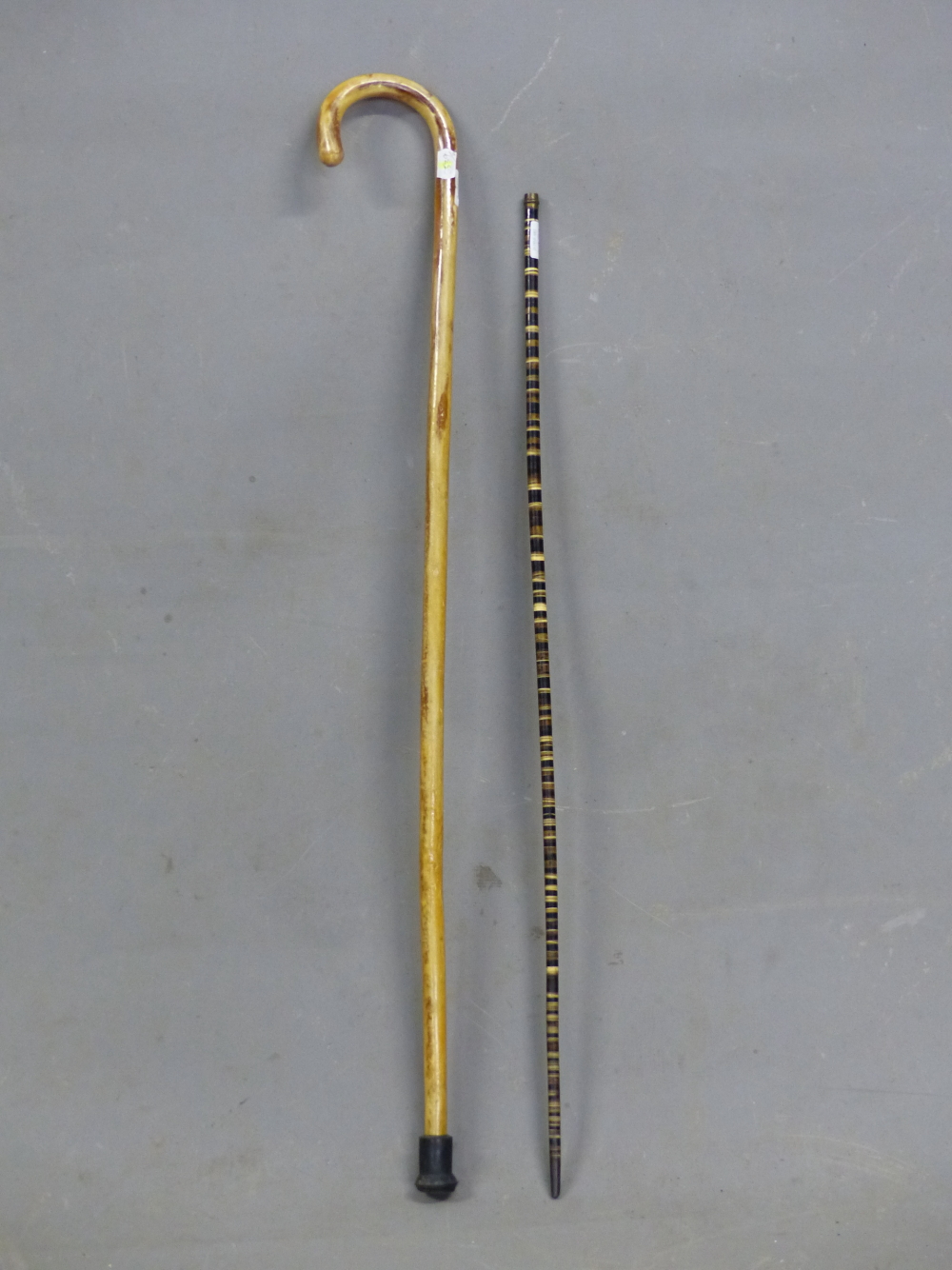 A HORN WALKING STICK OF AMBER HUE TOGETHER WITH A WALKING CANE FORMED OF HORN IN BANDS OF COLOURS