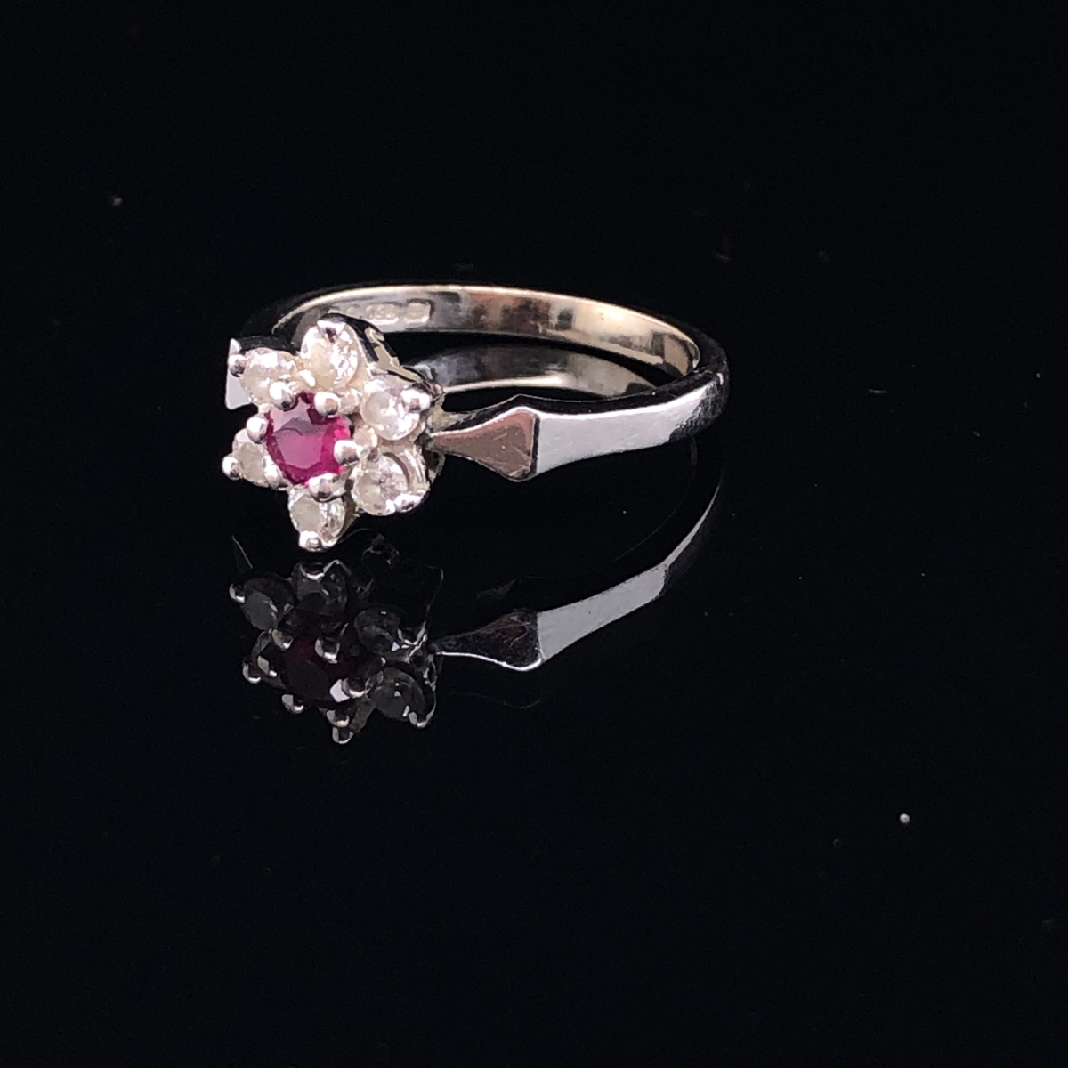 AN 18ct WHITE GOLD RUBY AND DIAMOND CLUSTER RING. THE RUBY A ROUND CUT IN A SIX CLAW SETTING - Image 2 of 3