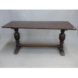 AN OAK REFECTORY TABLE, THE RECTANGULAR TOP ON CUP AND COVER COLUMNS. W. 168 x D. 74.5 x H. 76cms.