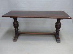 AN OAK REFECTORY TABLE, THE RECTANGULAR TOP ON CUP AND COVER COLUMNS. W. 168 x D. 74.5 x H. 76cms.
