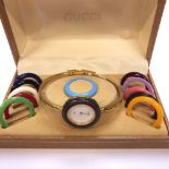 A GUCCI 1100-L GOLD PLATED LADIES BANGLE WATCH WITH TWELVE INTERCHANGEABLE BEZELS, COMPLETE WITH