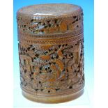 A CHINESE CARVED BAMBOO CYLINDRICAL BOX AND COVER DEPICTING WORKMEN AND TRAVELLERS IN A LEAFY