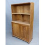 AN ARTS AND CRAFTS STYLE OAK BOOKCASE CABINET IN THE MANNER OF PETER WAALS, WITH SLIDING DOORS TO