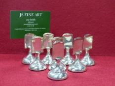 A SET OF EIGHT HALLMARKED SILVER PLACECARD HOLDERS WITH LOADED BASES, DATED 1924 BIRMINGHAM FOR