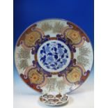 A FUKUGAWA IMARI CHARGER PAINTED ON THE RIM WITH CLUMPS OF BAMBOO ALTERNATING WITH FLOWERS ON A GOLD