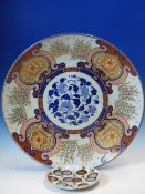 A FUKUGAWA IMARI CHARGER PAINTED ON THE RIM WITH CLUMPS OF BAMBOO ALTERNATING WITH FLOWERS ON A GOLD