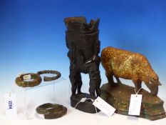 THREE AFRICAN METAL BANGLES, AN AFRICAN EBONY VASE HELD UP BY TWO FIGURES. H 29.5cms. AND A CAST