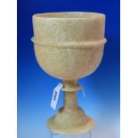 AN ALABASTER GOBLET VASE, THE BOWL ENCIRCLED BY A RIB, THE DISC KNOPPED STEM ON DOMED CIRCULAR FOOT.
