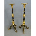 A PAIR OF GILT AND EBONISED TORCHERES WITH FOLIATE CARVED BALUSTERS ABOVE THE TRIPODS. H 130cms.