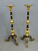 A PAIR OF GILT AND EBONISED TORCHERES WITH FOLIATE CARVED BALUSTERS ABOVE THE TRIPODS. H 130cms.