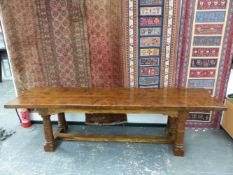 AN OAK REFECTORY TABLE, THE CLEATED THREE PLANK RECTANGULAR TOP ABOVE AN APRON JOINED BY BRACKETS TO