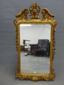 AN 18th.C. STYLE RECTANGULAR MIRROR, THE GILT FRAME WITH FOLIAGE CENTRED BROKEN ARCH PEDIMENT,