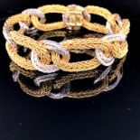 AN 18ct GOLD KUTCHINSKY BRACELET. COMPOSED OF A SERIES OF WHITE AND YELLOW GOLD OPEN TEXTURED