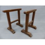 A PAIR OF OAK TRESTLES FORMED OF SQUARE SECTIONED BARS ON INVERTED T-SHAPED FEET. W 67.5 x H 73cms.