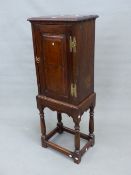 AN 18th C. OAK CUPBOARD, THE DOOR WITH RAISED PANEL AND BRASS HINGES. W 40 x D 28.5 x H 59cms. ON