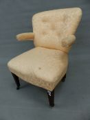 AN EDWARDIAN MAHOGANY BUTTON BACKED ARMCHAIR, THE ROUNDED ARMS CANTILEVERED FROM THE BACK, THE S