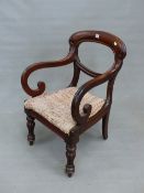 A VICTORIAN MAHOGANY BALLOON BACKED ELBOW CHAIR, THE ARMS WITH SCROLLED FRONTS ABOVE THE DROP IN SE