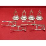 A SET OF FOUR HALLMARKED SILVER DOUBLE WISHBONE PLACE CARD HOLDERS WITH LOADED BASES FOR GEORGE