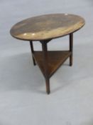 AN ANTIQUE OAK CRICKET TABLE ON SHAPED SQUARE LEGS WITH PLATFORM UNDER-TIER. 68cm (DIA) x 69cm (H).