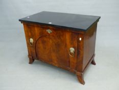 A BLACK MARBLE TOPPED MAHOGANY SIDE CABINET, THE COMPARTMENT DOOR WITH BRASS LION MASK AND RING