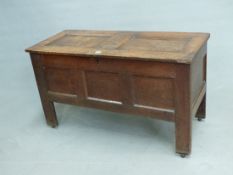 AN 18th C. OAK COFFER, THE TWO PANEL LID OVER THREE PANELLED FRONT BETWEEN STILE FEET. W 105.5 x D