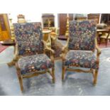 A PAIR OF BAROQUE STYLE WALNUT ARMCHAIRS, THE REEDED ARMS WITH FOLIATE HANDLES, THE STUFFED