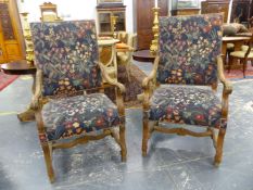 A PAIR OF BAROQUE STYLE WALNUT ARMCHAIRS, THE REEDED ARMS WITH FOLIATE HANDLES, THE STUFFED