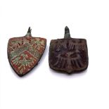 TWO MEDIAEVAL BRONZE SHIELD SHAPED PENDANTS, EACH WORKED WITH THREE SPREAD EAGLES, ONE WITH THE
