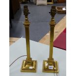 A PAIR OF GILT METAL SQUARE COLUMN TABLE LAMPS FLUTED BETWEEN THE BEADED TOPS AND FEET. H 48.5cms.