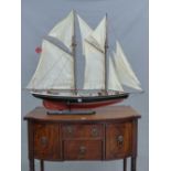 A MODEL YACHT NAMED DELAWANA, THE TWO MASTS BEARING EIGHT SAILS ABOVE THE PLANKED DECK AND