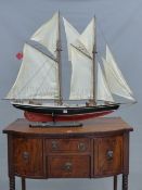 A MODEL YACHT NAMED DELAWANA, THE TWO MASTS BEARING EIGHT SAILS ABOVE THE PLANKED DECK AND