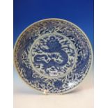 A CHINESE BLUE AND WHITE DISH, THE CENTRAL DRAGON ROUNDEL ENCLOSED BY A BAND OF DRAGON PHOENIX AND