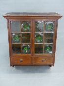 A VICTORIAN OAK WALL CABINET, THE PEDIMENT OVER DOORS GLAZED IN CLEAR AND GREEN BOTTLE END GLASS