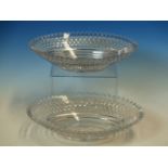 A PAIR OF OVAL CUT GLASS DISHES, THE SERRATED RIMS OVER BANDS OF DIAMOND DIAPER. W 24.5cms.